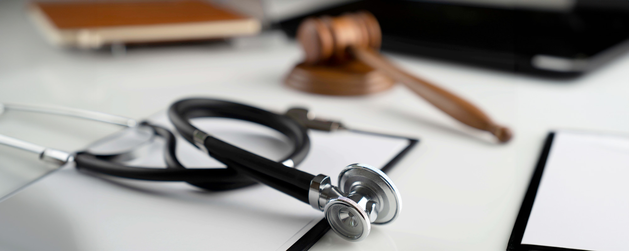 Gavel notebook and stethoscope on the white table